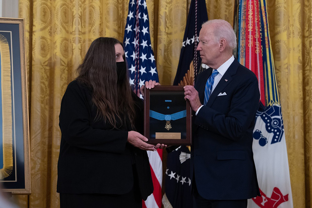 President Joe Biden presents the Medal of Honor to Tamara Cashe, widow of Army Sgt. 1st Class Alwyn Cashe during a White House ceremony on Dec. 16, 2021. Cashe was posthumously awarded the Medal of Honor for actions of valor during Operation Iraqi Freedom while serving as a platoon sergeant with Alpha Company, 1st Battalion, 15th Infantry Regiment, 3rd Infantry Division, in Salah Ad Din province, Iraq, on Oct. 17, 2005. © Laura Buchta / U.S. Army