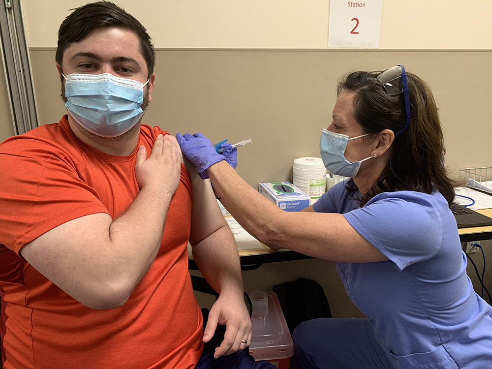 Dr. April Kapu, President of the American Association of Nurse Practitioners administering the COVID-19 vaccine to a patient