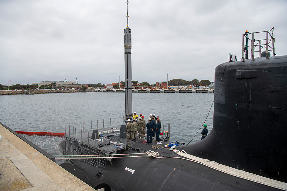 U.S. sailors assigned to the USS Mississippi and explosive ordnance support personnel from Thales Australia lower an inert Tomahawk missile training shape into the submarine while moored at HMAS Stirling Navy Base on Garden Island, Dec. 1, 2022. © Marine Corps Lance Cpl. John Hall