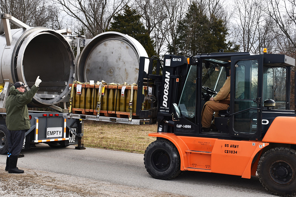 Toxic materials handlers guide munitions into a container during munitions movement training at the Blue Grass Army Depot, Ky., Feb. 13, 2019. © DOD