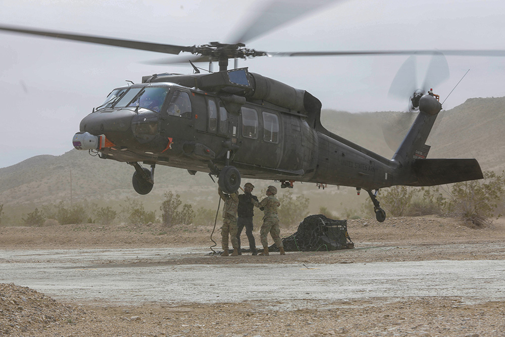 Soldiers load cargo for a UH-60A Black Hawk helicopter during an autonomous flight as part of an experiment at Fort Irwin, Calif., on March 10, 2024. © Army Spc. Zion Thomas