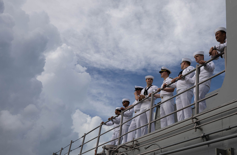 Sailors take in the view on the flight deck aboard the amphibious assault ship USS Wasp as the ship pulls into port in Nassau, The Bahamas, June 28, 2023. © Navy Seaman Apprentice Alice Husted