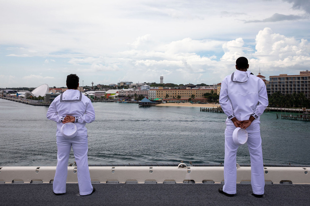 Sailors take in the view on the flight deck aboard the amphibious assault ship USS Wasp as the ship pulls into port in Nassau, The Bahamas, June 28, 2023. © Navy Seaman Kaitlin Young