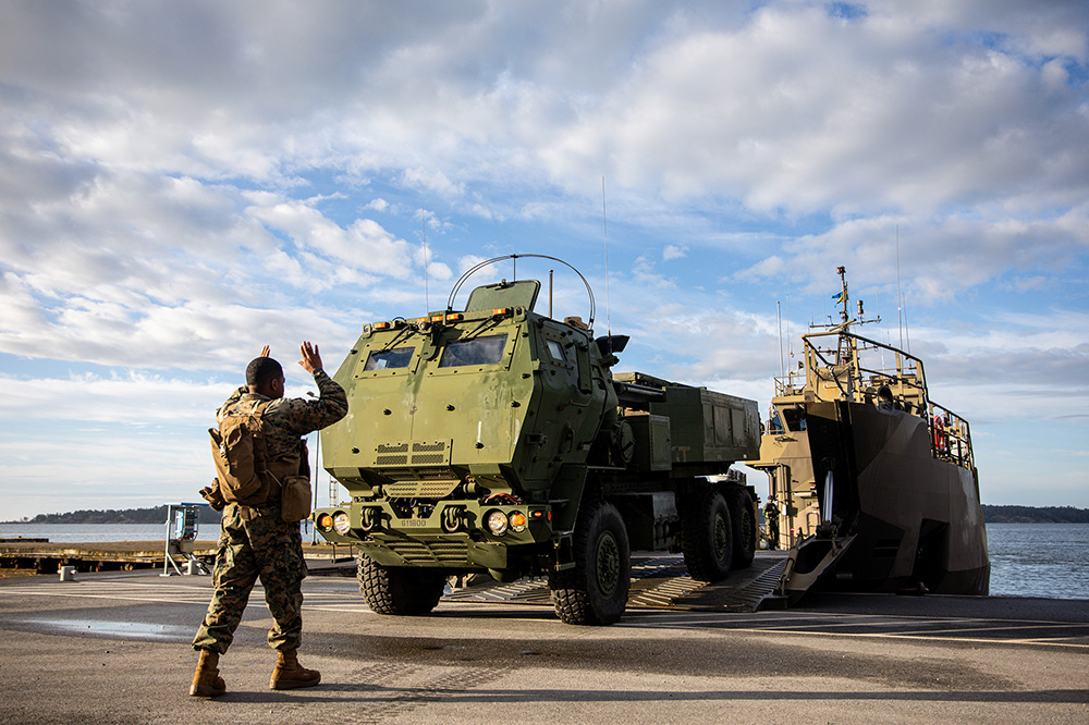 A Marine directs a High Mobility Artillery Rocket System onto the ramp of a ship during exercise Baltic Operations 24 in Camp Berga, Sweden, June 11, 2024. The exercise is led by U.S. Naval Forces Europe-Africa and provides a unique training opportunity to strengthen combined response capabilities in the Baltic Sea. © Marine Corps Sgt. Emely Gonzalez