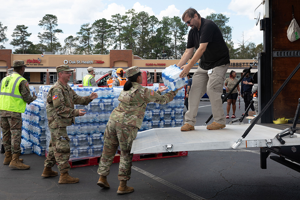 Georgia Army National Guard soldiers work with Georgia State Defense Force personnel to unload cases of water during a point of distribution mission in Augusta, Ga., Sept. 30, 2024. Guardsmen mobilized to provide response and recovery support to areas affected by Hurricane Helene. © Army National Guard Spc. Ayanna Tillman