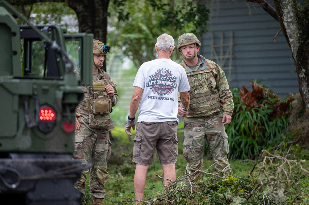 Florida Army National Guard, Sgt. Ryan Leidle, left, and Sgt. Austin Fennecken, Multiple Launch Rocket System crewmembers with 3rd Battalion, 116th Field Artillery Regiment, check in with a resident affected by Hurricane Milton during a survey and assist patrol in Kissimmee, Fla., Oct. 10, 2024. © Army Sgt. Marc Morgenstern