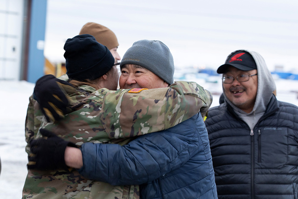 Army Chief Warrant Officer 2 Morgan Osborn, left, a UH-60L Black Hawk pilot greets local resident, Nick Therchik, after delivering thousands of pounds of frozen meat during an innovative readiness training mission at Toksook Bay, Alaska, Nov. 18, 2024. © Army Staff Sgt. Seth LaCount